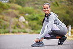 Active and fit woman tying the laces of her sneakers for exercise outdoors. Athlete fixing her shoes to get ready for a run or jog in the morning. Preparing for a refreshing cardio workout outside