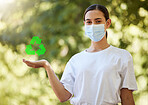 Closeup of a beautiful young woman in a mask holding copyspace showing a recycle sign. Depicting the importance of looking after the environment, going green and saving our planet. Zero waste