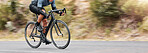 Young man showing his cycling skills while out cycling on a bicycle outside. Adrenaline junkie practicing a speed racing outdoors. Unrecognizable male training for a marathon on a bike 