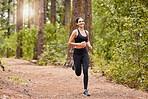 Young caucasian female athlete running outside in nature on the road. Exercise is good for your health and wellbeing. Running in a forest in the morning. Enjoying, relaxing, positive. 