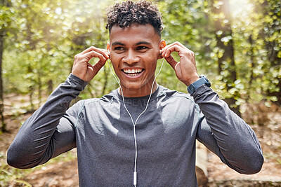 Buy stock photo Nature, smile and music with man in park for fitness, audio streaming and cardio. Health, exercise and workout with runner and earphones training in forest for sports, performance and wellness