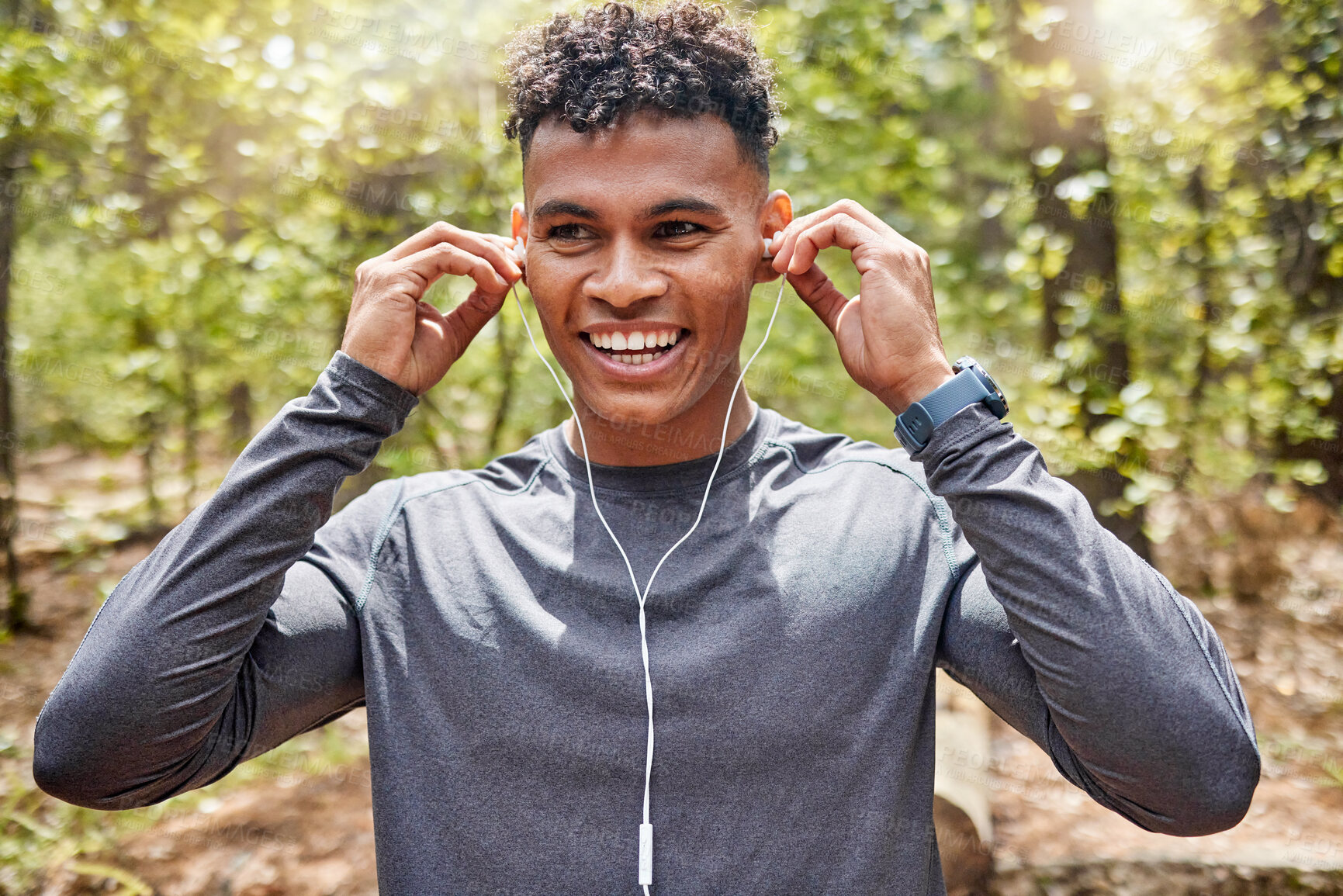 Buy stock photo Nature, smile and music with man in park for fitness, audio streaming and cardio. Health, exercise and workout with runner and earphones training in forest for sports, performance and wellness