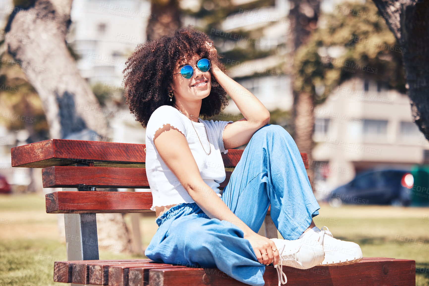 Buy stock photo Fashion, sunglasses and happy woman at park bench in city for style, trendy and vision. African girl, cool and relax outdoor or thinking of streetwear or reflection with urban accessory in summer