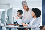 African american call centre telemarketing agent training new mixed race assistant on a computer in an office. Team leader and supervisor troubleshooting solution with intern for customer service and sales support. Colleagues operating helpdesk together