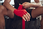 Closeup of boxer wrapping their hands in bandages. Hands of mma fighter wrapping a bandage on their hands. Boxer getting ready for training routine cropped. Strong boxer prepare for workout