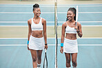 Smiling tennis players holding their rackets on the club court. Two young friends bonding and talking after a practice tennis match. Friends playing tennis as a hobby on the weekend