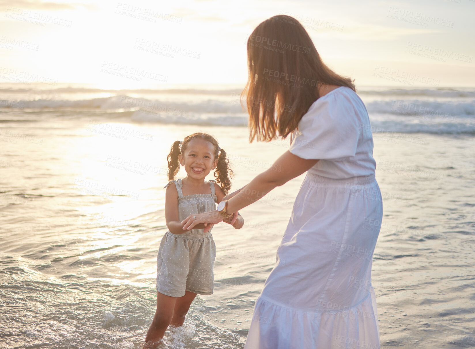 Buy stock photo Mother, girl and holding hands in water on beach for adventure, summer vacation and family time together. Waves, mom and daughter by play sea for holiday with bonding, love and fun to explore nature.