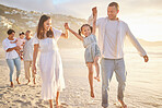 Cute little girl swinging while holding hands with her parents. Young mom and day walking hand in hand with their daughter and lifting her while walking on the beach. Family fun in the summer sun