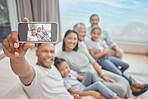 Happy and affectionate young mixed race family of six taking a selfie at home. Married couple with their mother, father, son and daughter in the lounge. Taking a photograph with with grandparents