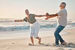 Cheerful mature couple playing on the beach. Senior couple having fun on the beach together. Happy senior couple being carefree by the ocean together. Mature couple bonding on the beach together