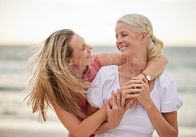 Buy stock photo Hug, beach and senior mom with daughter for bonding holiday, love and embrace on weekend travel. Nature, mother and woman laughing on ocean adventure together with smile, fun and island vacation.