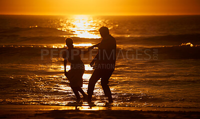 Buy stock photo Love, beach and silhouette of playful couple at sunset for bonding holiday, fun and tropical travel. Nature, man and woman on romantic ocean date together with waves, orange sky and outdoor vacation