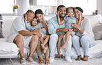 Happy and content hispanic family smiling while relaxing and sitting on the couch together at home. Cheerful and carefree little brother and sister enjoying time with their parents and grandparents