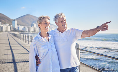 Buy stock photo Pointing, happy and mature couple in beach, hug and bonding in vacation for fresh air, smile or nature. Holiday, old man and woman for romance in Australia, travel and date in ocean, enjoy or weekend