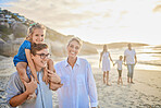 Multi generation family holding hands and walking along the beach together. Caucasian family with two children, two parents and grandparents enjoying summer vacation