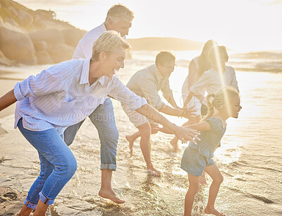 Buy stock photo Holding hands, beach and big family with vacation, happiness and travel for adventure, fun and play. People, sunset and grandparents with mother, father and kids with childhood, smile and energy