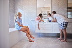 Happy family with two children brushing teeth. Young caucasian couple teaching their children to practice good oral hygiene. Set a good example by making brushing teeth a family activity