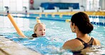 Instructor, active and girl in pool, swimming or woman with smile, proud and helping child in water. Bathing suit, happy and learning with teacher in school for training of kid, sports or competition