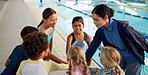 Swimming pool, lesson and teacher with kids in huddle for learning, practice and training. Teamwork, celebrate and swimmer instructor with happy children for exercise, fitness and water sports class