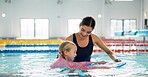 Instructor, teaching and child in pool, swimming or woman with smile, proud or helping girl in water. Bathing suit, happy or learning with teacher in school for training of kid, sports or competition