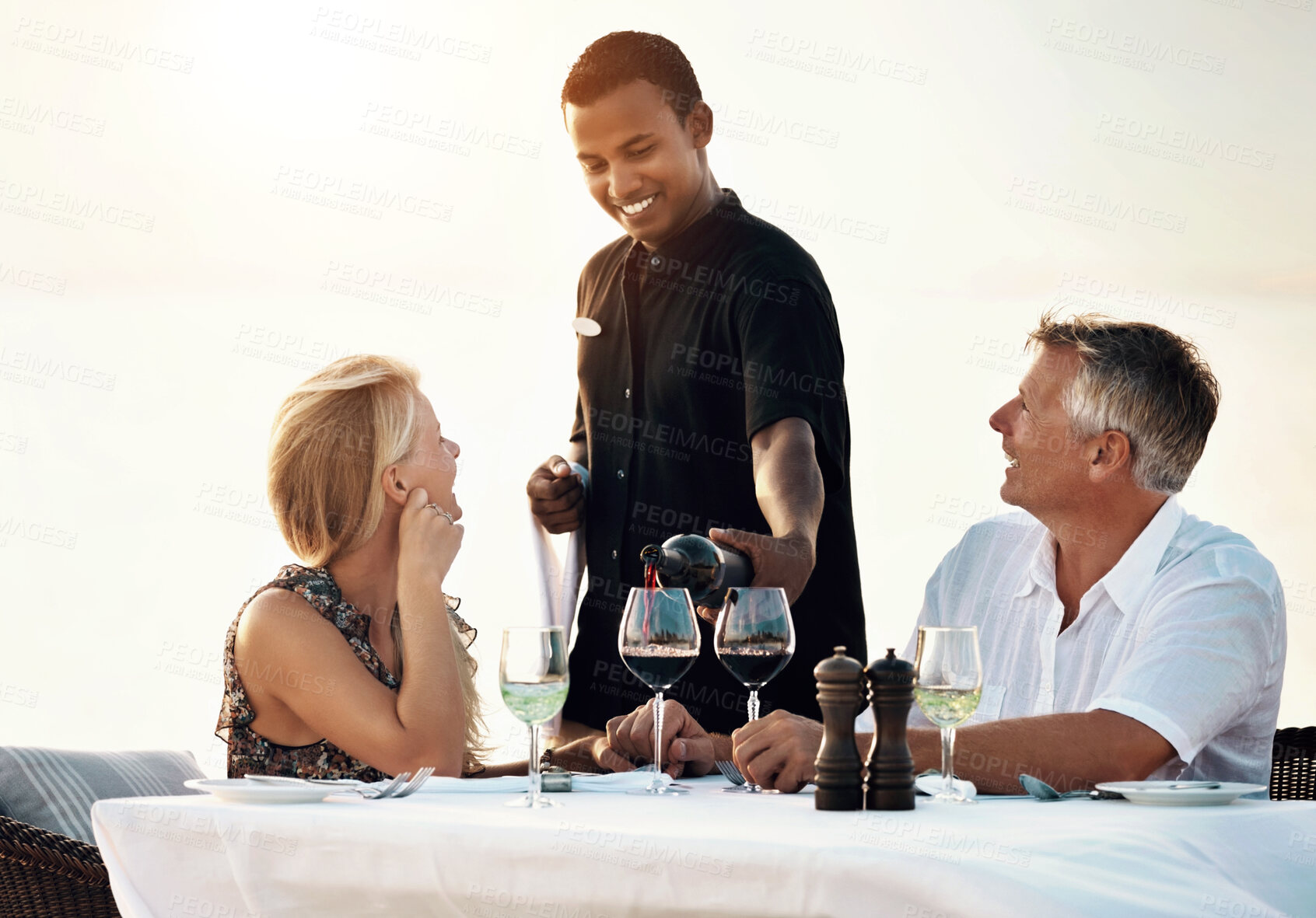 Buy stock photo Shot of a mature couple enjoying a romantic dinner on the beach