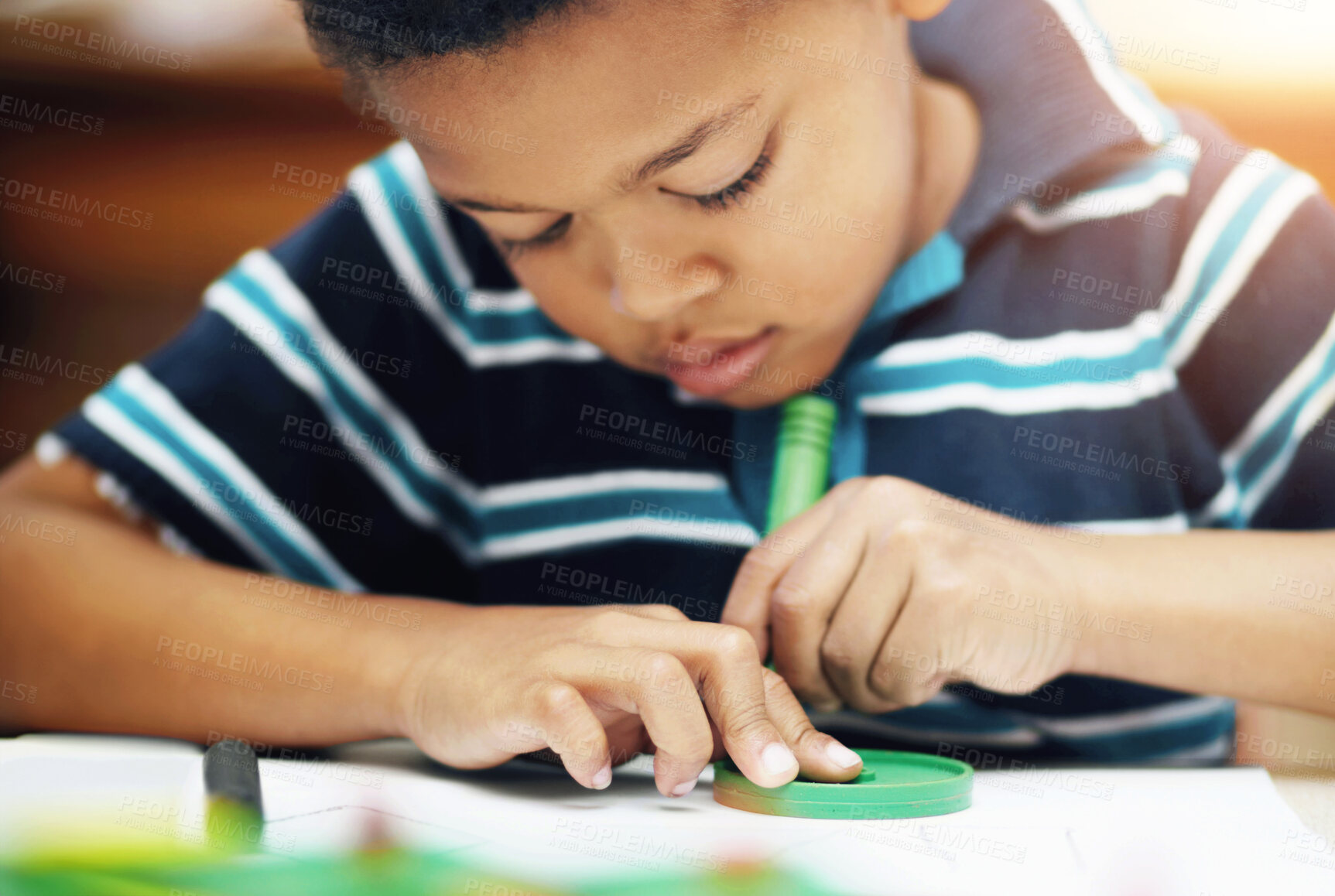 Buy stock photo Pre-school african american boy concentrating on his drawings with his crayons and shapes