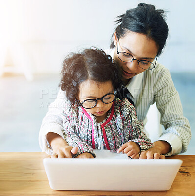 Buy stock photo A cute little girl sitting on her mother&amp;#039;s lap while working on the computer