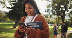 Student, black woman and books in park on smartphone on walk with education, learning or chat on web at campus. Person, reading and app with smile, social network or scholarship at college in Brazil