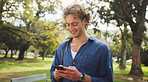 Student, man and phone with texting, park and reminder for class for education, learning and chat at campus. Person, smartphone and reading on path, mobile app and scholarship at college in Germany