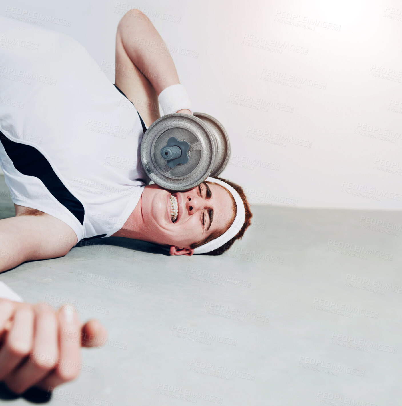 Buy stock photo Fitness, face and dumbbell with an unlucky man in the gym after an accident while lifting heavy weights. Exercise, injury or pain with a young person making a mistake during a training workout