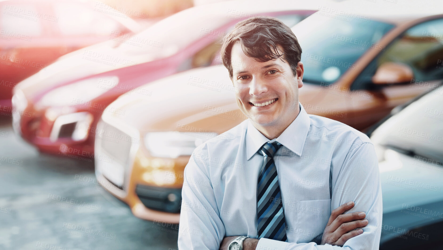 Buy stock photo A man smiling confidently while standing in the lot of his dealership