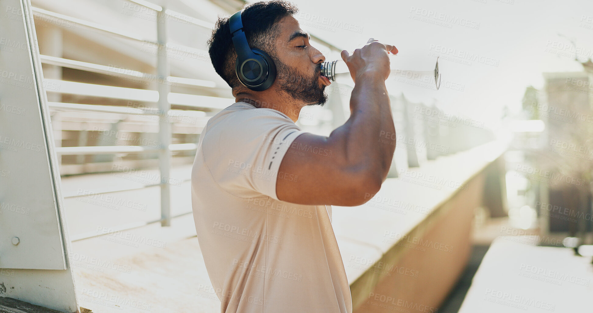 Buy stock photo Fitness, drinking water and man in city with headphones, break and hydration in training. Athlete, bottle or music on run for workout, healthy body or rest on sidewalk with nutrition or care in sport