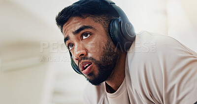 Buy stock photo Thinking, headphones and man with training, tired and fatigue with sound, listening to music and burnout. Male person, runner or exhausted athlete with song for motivation and exercise low angle