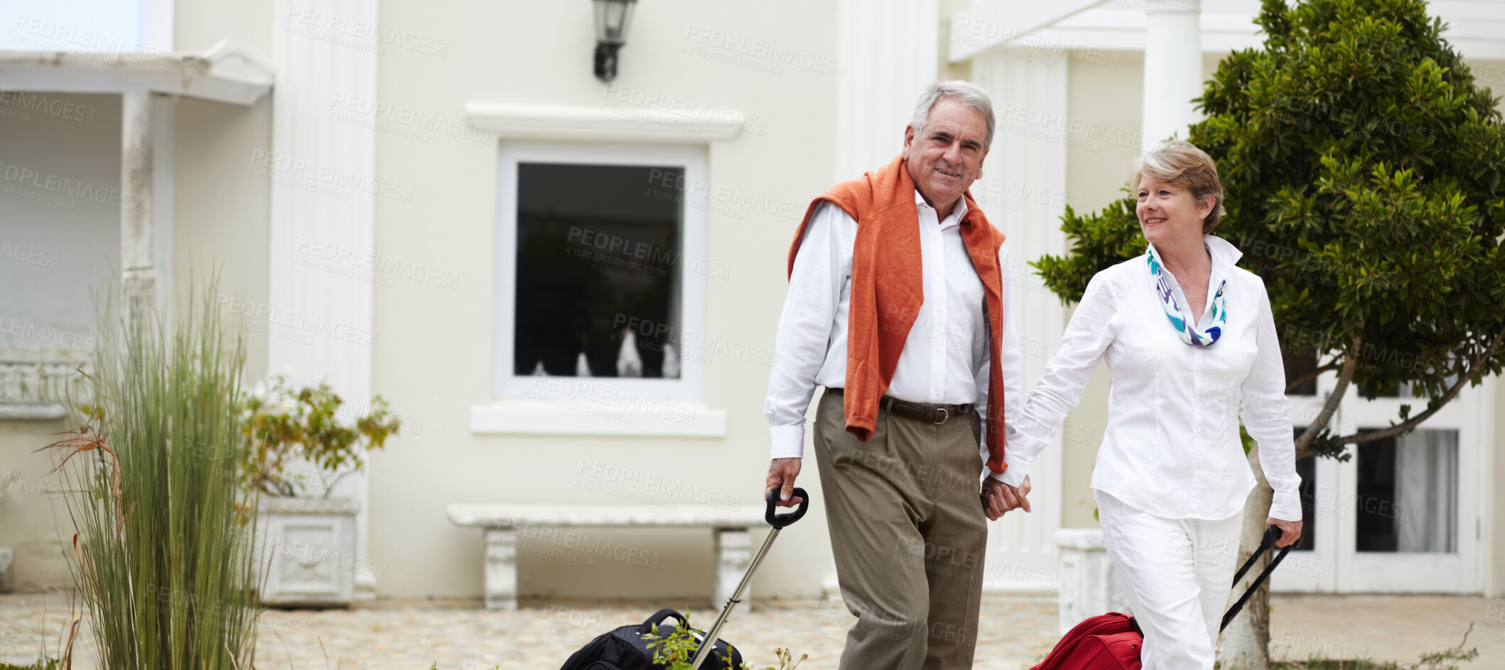 Buy stock photo Portrait of a senior couple arriving at their hotel with their suitcases in tow