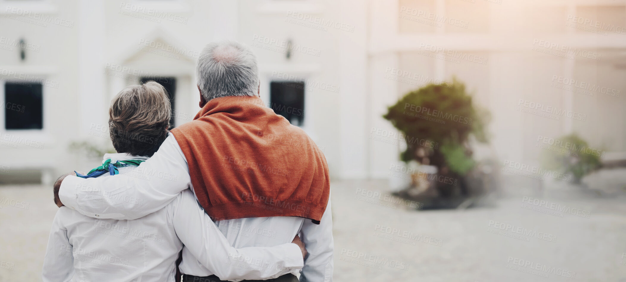 Buy stock photo Rear view of a senior couple embracing each other in the courtyard of their hotel