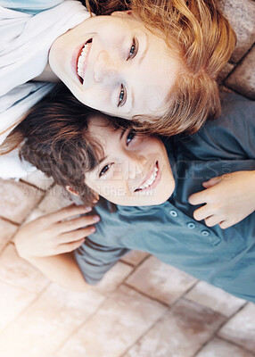 Buy stock photo Portrait of a brother and sister lying on the floor with their heads together