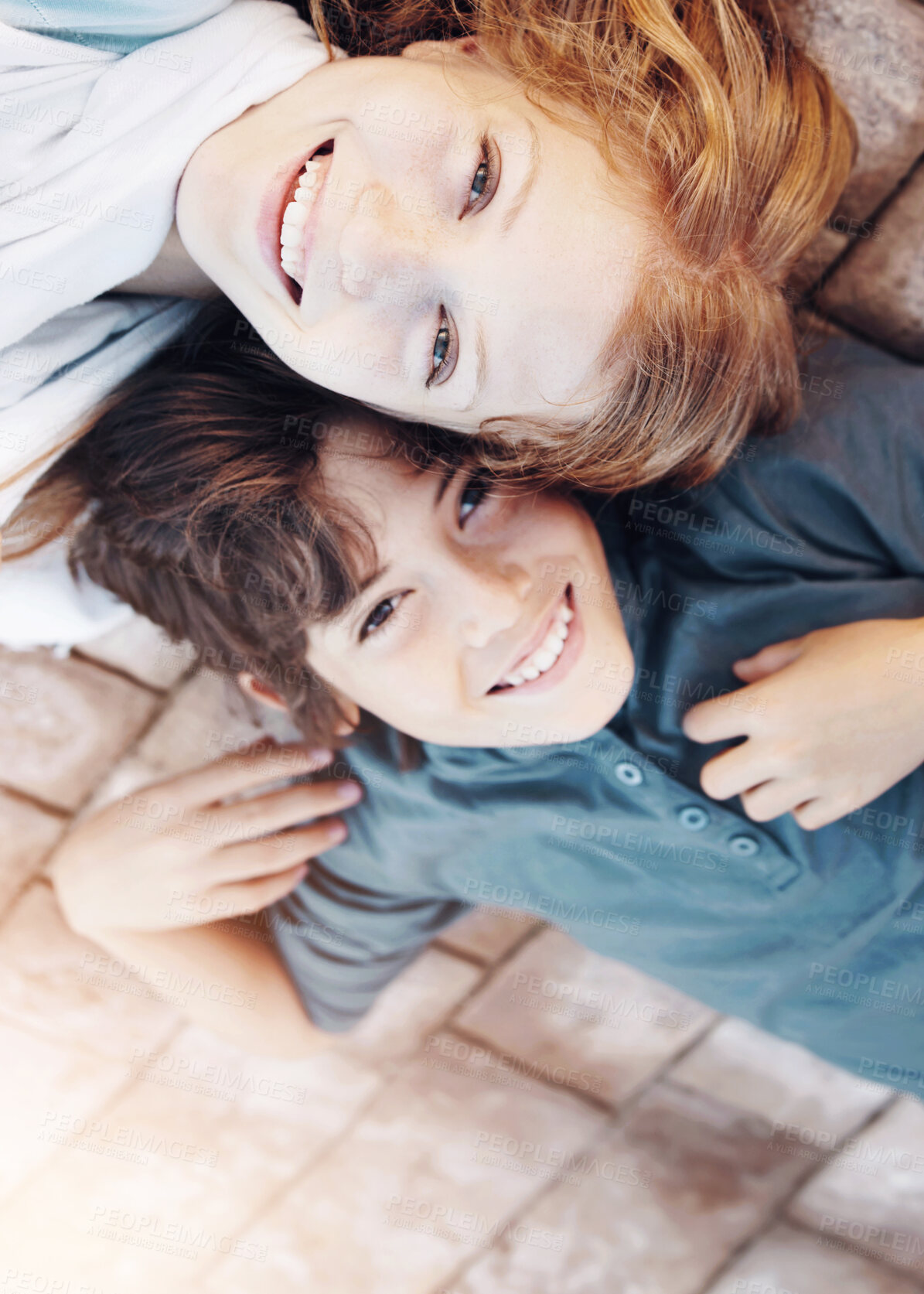 Buy stock photo Portrait of a brother and sister lying on the floor with their heads together