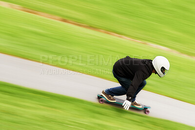 Buy stock photo Shot of a man skateboarding down a lane at high speed on his board