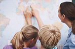 World map, back and students with educator, pointing and conversation with creativity. Geography, woman and kids in school, children or studying with answers, conversation and learning in classroom