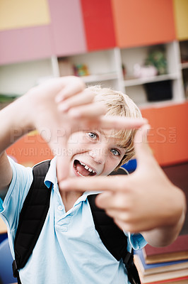 Buy stock photo Finger, frame and boy with funny portrait in classroom for creative imagination, education perspective and happy. Learner, person and hand emoji at elementary school for learning, shape and symbol