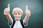 Portrait, happy child and thumbs up by chalkboard for learning, quality education and success. Face, kid and boy at school with like hand gesture for agreement, yes and student recommend scholarship