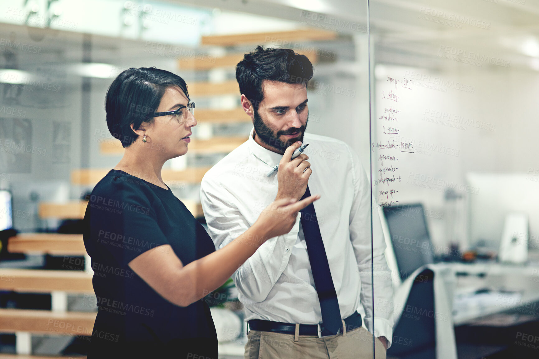 Buy stock photo Cropped shot of businesspeople brainstorming with notes on a glass wall in an office