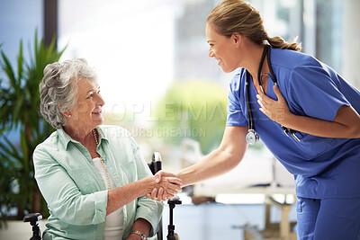 Buy stock photo Shot of a doctor shaking hands with a smiling senior woman sitting in a wheelchair