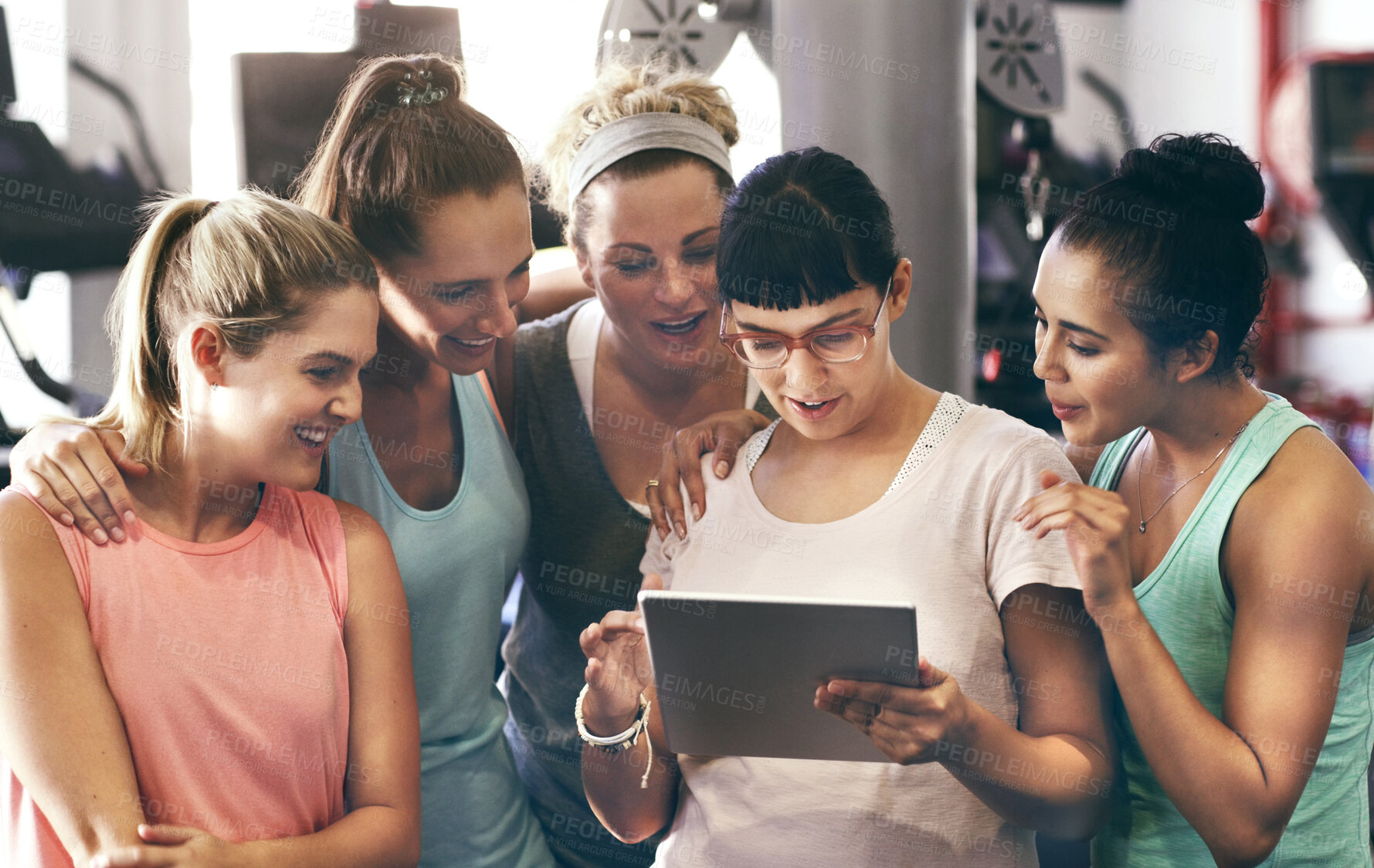 Buy stock photo Cropped shot of a group of young women looking at a digital tablet in the gym