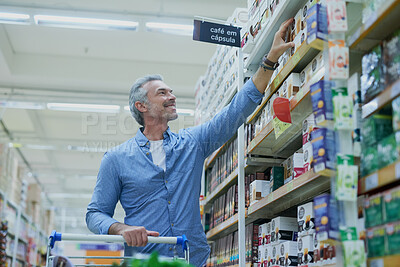 Buy stock photo Happy, shopping and man in supermarket with shelf for food, grocery and products at convenience store. Retail, consumer and person with trolley in aisle for choice, options and discount purchase