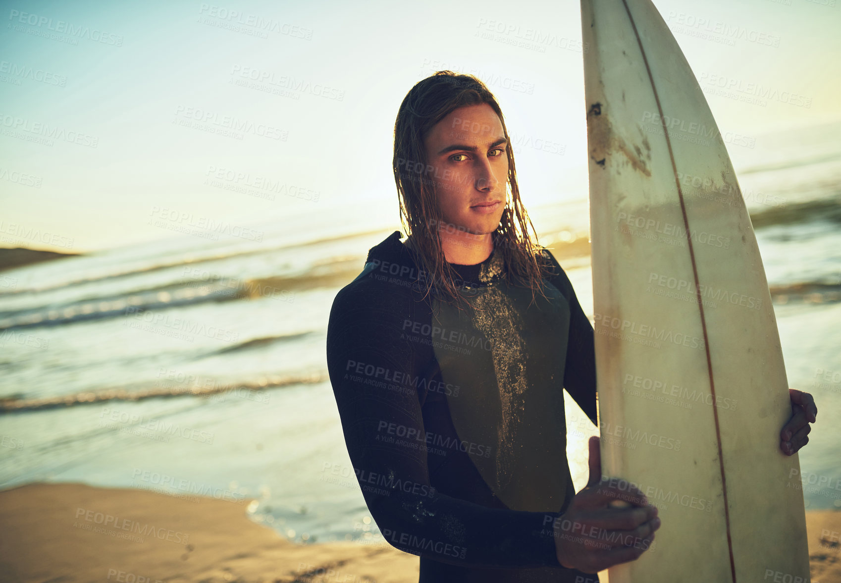 Buy stock photo Man, surfboard and portrait on beach for fitness, training programme and competition preparation. Athlete, surfer and sunset at ocean with sport, recreational activity and confidence in Australia