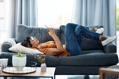 Buy stock photo Woman, relax and smile with phone on sofa for communication, social media and reading ebook on website. Rest, female person and glasses with mobile for online news, typing email and contact at house