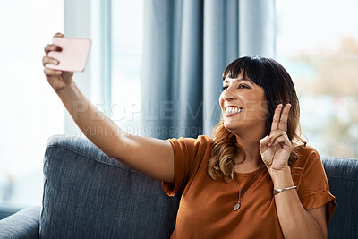 Buy stock photo Woman, home and peace sign on sofa for selfie on break for social media post, interaction and profile picture. Female person, happiness and couch in living room for content creation and photo album