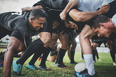 Buy stock photo Low angle shot of two young rugby teams competing in a scrum during a rugby match on a field