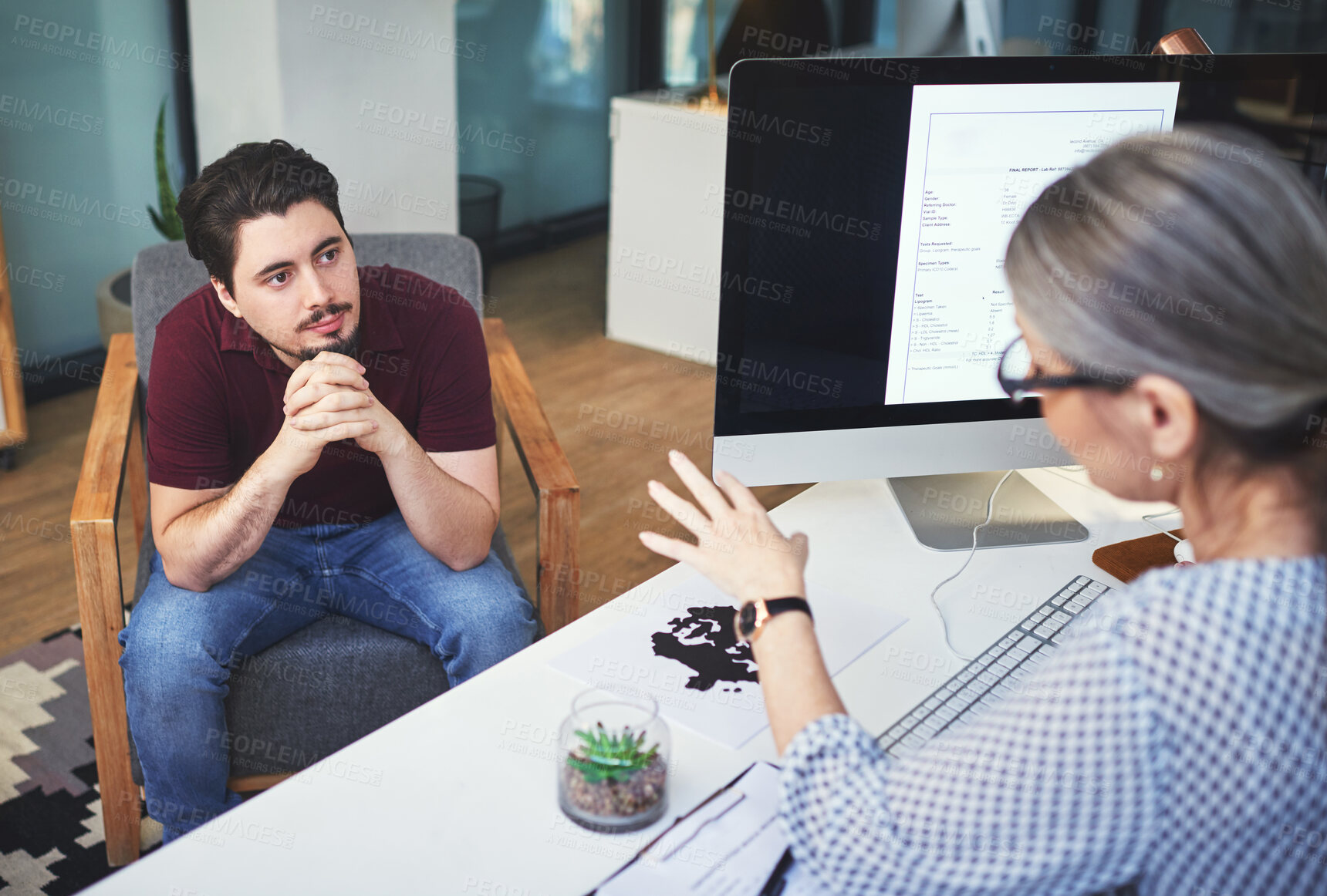 Buy stock photo Shot of a young man having a therapeutic session with a psychologist